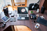 A contemporary office desk setup with laptops, gadgets, and accessories, creating a tech-savvy workplace.