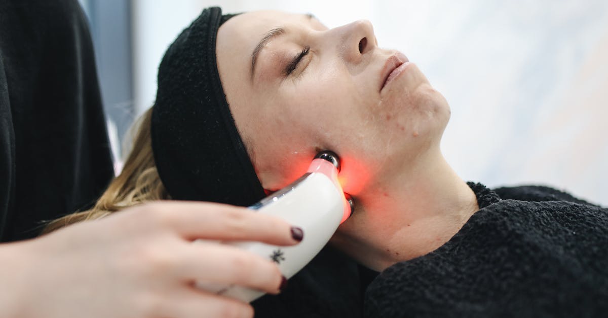 An adult woman receives a laser facial treatment in a modern skincare clinic.